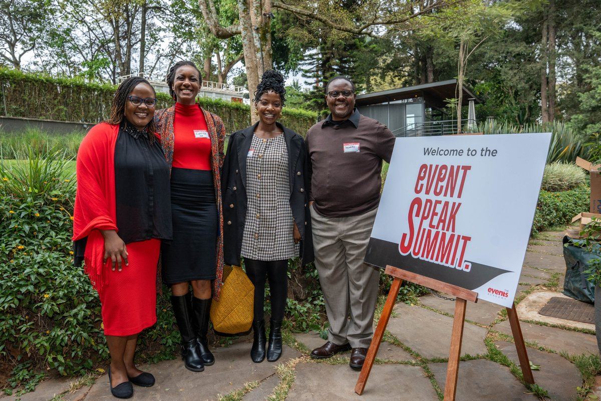 Delegates beside the Event Speak Summit welcome sign