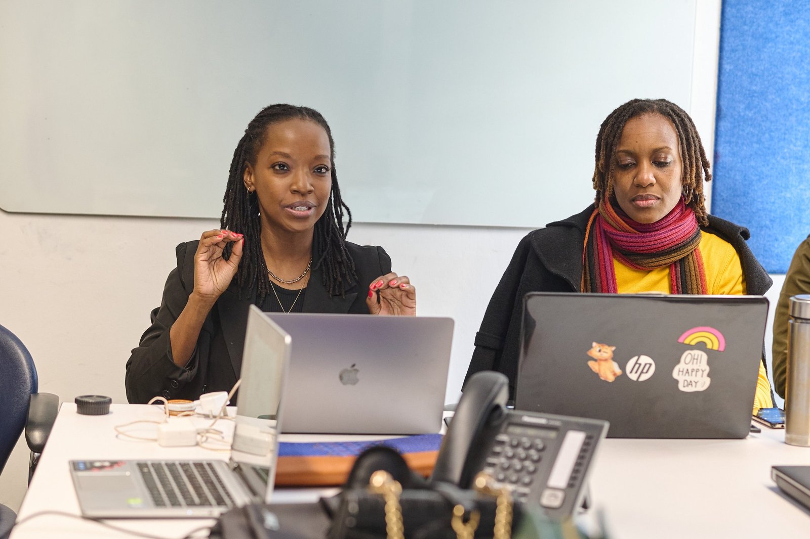 Two students working on their business plans on laptops in class