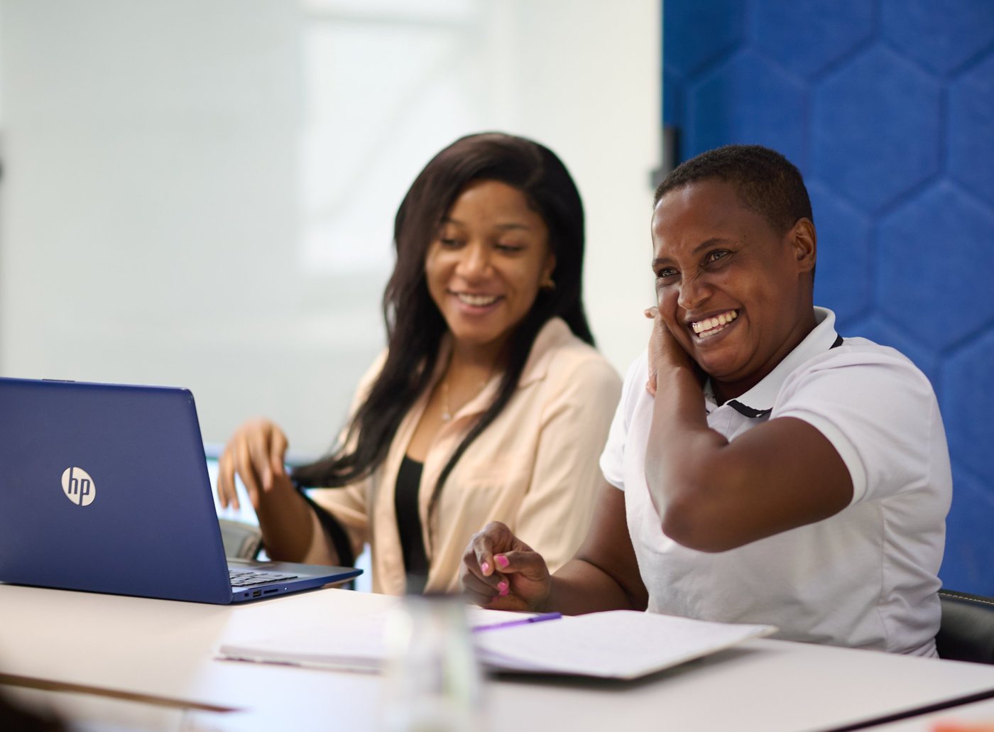 Two students laughing together during a class at the academy